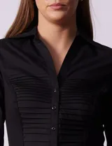 Camisa negra de algodón con cuello con solapa, abertura central con botones, delantera tableada y mangas 3/4. Laterales elastizados.