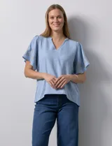 Blusa color beige de crepe, marca Batía, con cuello a la base y escote en V. Manga corta amplia con bordados.