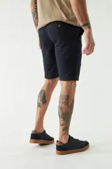 Bermuda de gabardina color beige, corte chino, con bolsillos laterales y traseros, cierre con cremallera y botón, presillas para cinturón y logo bordado.