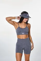 Conjunto deportivo gris jaspeado compuesto por top con breteles finos y logo 'bk.' estampado en el frente, y short de calce ajustado.