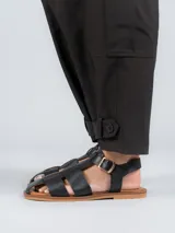 Sandalias bajas doradas con diseño de tiras entrecruzadas y hebilla lateral.