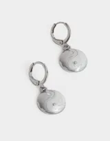 Aros dorados con forma de argolla y dije colgante con diseño de yin yang esmaltado en blanco y dorado.