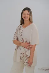 Blusa beige con estampado de hojas marrones, cuello en V y corte holgado.