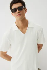 Remera blanca de punto texturizado con cuello y miniabertura en V.