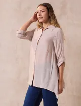 Camisa larga color beige de rayón, marca Robert Louis. Cuello con solapa y abertura central con botones. Largo de manga regulable con presilla y botón. Laterales con tajo.