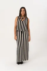 Pollera larga tejida a rayas verticales negras y beige, con pretina elástica y tajos laterales.