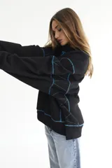 Buzo negro de felpa de algodón con pespuntes en zigzag color celeste y logo bordado en el pecho.