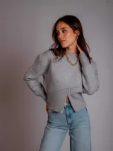 Sweater color beige de tejido de punto con cuello redondo y cierre frontal parcial.