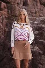 Pollera corta tejida color camel, de punto liso, con cintura alta y ruedo con volado.