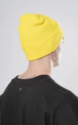 Gorro de lana amarillo tejido con poliéster y acrílico, con logo de la marca en etiqueta negra.