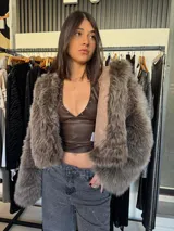 Campera corta color marrón con detalles de piel sintética en mangas y cuello.
