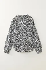 Camisa de manga larga con estampado geométrico en blanco y negro, cuello mao y cierre parcial con botones.