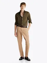 Camisa verde militar de popelín de algodón con tecnología Flex, corte regular, cuello con botones, puños redondeados con botón y logo de Tommy Hilfiger bordado en el pecho.