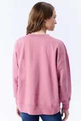 Buzo deportivo rosa de corte holgado y mangas largas.