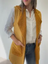 Chaleco largo sin mangas de diseño italiano, con textura suave y bolsillos frontales.