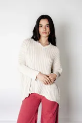 Poncho tejido de punto color crudo con lurex, de calce suelto y relajado.