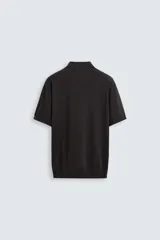 Polo negro de punto tejido en hilatura con algodón y lyocell, corte regular fit, cuello solapa con cierre frontal de botonadura, manga corta y acabados en rib.