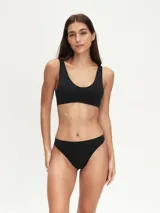 Colaless blanca de tejido liso, sin costuras (seamless), con corte bajo y tiro bajo.