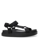 Sandalias planas color beige con tiras anchas acolchadas y ajuste con velcro en el tobillo.