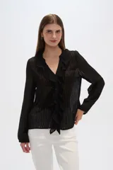Blusa negra semitransparente con rayas verticales, cuello en V con volados y cierre frontal con botones.