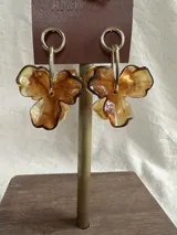 Aros colgantes con forma de flor de acrílico color ámbar, con gancho dorado.