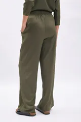 Pantalón de mujer color verde militar, de tiro alto y corte ancho (wide leg), confeccionado en tela con textura acanalada o plisada.