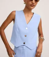 Chaleco negro de crepé con escote en V y abotonadura dorada. Corte slim y sin mangas.