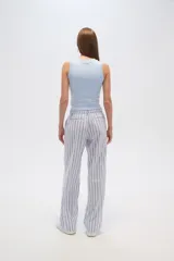 Pantalón de algodón a rayas verticales celestes y blancas, de corte holgado y tiro alto.