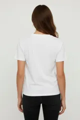 Remera de algodón color beige, manga corta y cuello redondo, con estampado frontal de una flor azul y texto en foil dorado que dice "You are Unique".