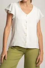 Blusa blanca con escote en V, mangas cortas con volados y cierre frontal con botones.