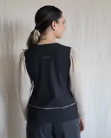 Remera negra de mangas largas con cuello en V y detalles de pespuntes blancos.