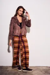 Campera estilo biker de gamuza sintética color malva o marrón rosado, con cierre asimétrico y detalles de tachas doradas en solapas y hombros.