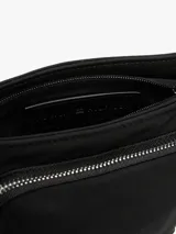 Bandolera Tommy Hilfiger negra de poliéster con acabado texturizado. Tiene correa ajustable, cierre de cremallera, bolsillo interior y exterior con cremallera, logo de Tommy Hilfiger grabado en bajo relieve en el interior y logo metálico en la parte delantera.