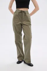 Pantalón de algodón color beige, de corte recto y tiro medio, con bolsillos laterales y cintura con cordón ajustable.