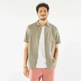 Camisa de manga corta color verde oliva con cuello clásico y cierre abotonado. Presenta un sutil estampado floral bordado en toda la prenda.