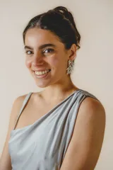 Vestido largo plateado de corte ajustado, con escote asimétrico, espalda descubierta y tajo lateral.