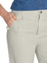 Pantalón de lino color beige, tiro alto, corte ancho, con bolsillos laterales y elástico en los tobillos.