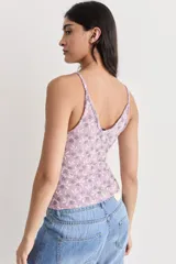Musculosa de encaje color lila con estampado de flores blancas y grises, de breteles finos y corte ajustado.