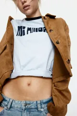 Remera celeste con cuello y mangas con ribete azul marino. Estampa frontal con la frase "Mi Amore" en azul marino.