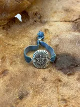 Pulsera dorada con dije circular con la figura del Espíritu Santo y banda de terciopelo verde.