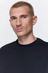 Buzo azul marino de tejido de mezcla de algodón de peso medio con interior cepillado suave. Modelo con cuello redondo ribeteado, hombros caídos y remate acanalado ancho en puños y bajo. Corte holgado.