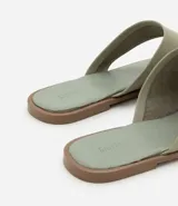 Sandalia plana tipo mule color crema, con puntera cuadrada, tira ancha en la parte superior y detalle de dedo.