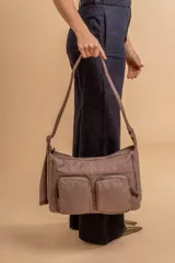 Bandolera de tafeta impermeable, liviana, con dos compartimientos principales, dos bolsillos con cierre y correa regulable con hebilla.