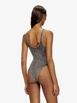 Body de tirantes color gris oscuro con efecto lavado o 'acid wash', corte ajustado y escote redondo. Presenta un parche rectangular con texto en la zona del pecho.