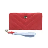 Billetera roja con diseño acolchado en forma de V y logo metálico de labios en la parte superior. Incluye cierre perimetral y correa de muñeca.