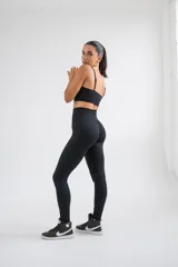 Calza deportiva negra con estampado de líneas onduladas en relieve.