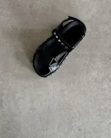 Sandalia de cuero vacuno negras con detalles de tachas en la suela, diseño clásico estilo Teva.