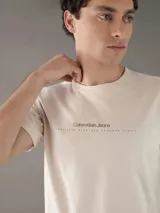 Remera color crema de corte clásico con cuello redondo y mangas cortas. Estampado pequeño en el pecho con el logo de Calvin Klein Jeans y la leyenda 'Established Nineteen Seventy Eight'.