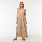 Vestido largo color beige, de breteles finos y corte imperio, con falda escalonada de tres niveles.
