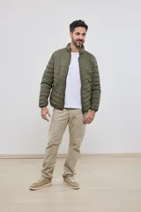 Campera capitoneada liviana color azul marino, con cuello alto y dos bolsillos exteriores con cierre. Interior del cuello a contratono.